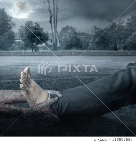 A zombie hand with a bloody wound grabs a human leg with full moon background. Scene has dark and scary. Zombie, devil, evil, satan, or monster hands A zombie hand with a bloody wound grabs a human leg with full moon background. Scene has dark and scary. Zombie, devil, evil, satan, or monster hands 118892686