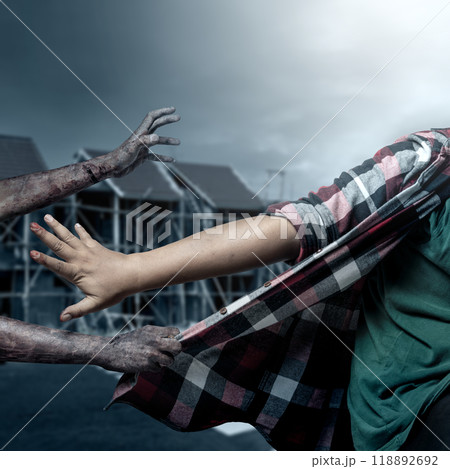 A zombie hand with a bloody wound grabs a human shirt with midnight background. Scene has dark and scary. Zombie, devil, evil, satan, or monster hands A zombie hand with a bloody wound grabs a human shirt with midnight background. Scene has dark and scary. Zombie, devil, evil, satan, or monster hands 118892692