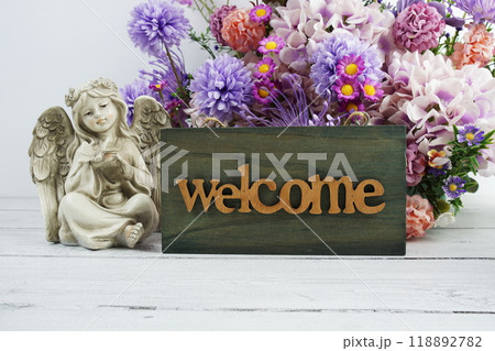 Welcome sign with flowers bouquet and angel statues home decorations 118892782
