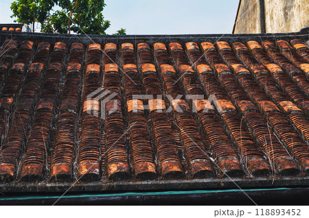 Ancient traditional orange tiles on roof of an Asian old house in Asia 118893452
