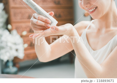 ボディクリームをチューブから出す若い女性 118893671