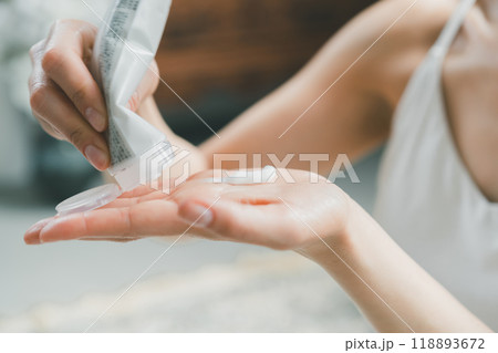 ボディクリームをチューブから出す若い女性 118893672