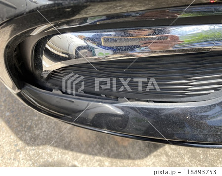 Close-up of the headlight of a modern black car after accident on the road 118893753