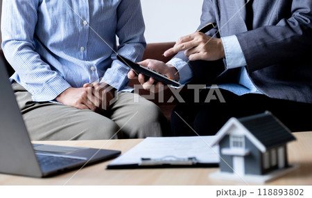 The real estate agent explains the business contract, rent, purchase, mortgage, a loan, or home insurance to the women buyer The real estate agent explains the business contract, rent, purchase, mortgage, a loan, or home insurance to the women buyer 118893802