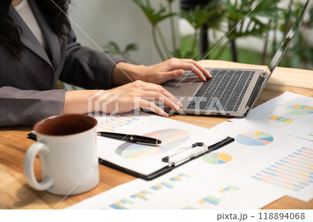 Businesswoman analysis the graph with laptop at the home office for setting challenging business goals And planning to achieve the new target 118894068