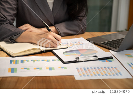 Businesswoman hand holding pen, analysis the graph with laptop at the home office for setting challenging business goals And planning to achieve the new target 118894070