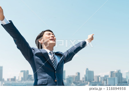 青空の中で叫ぶ若いアジア人ビジネスマン（転職・勝利・就職・脱サラ・チャレンジ・頑張る・達成） 118894938