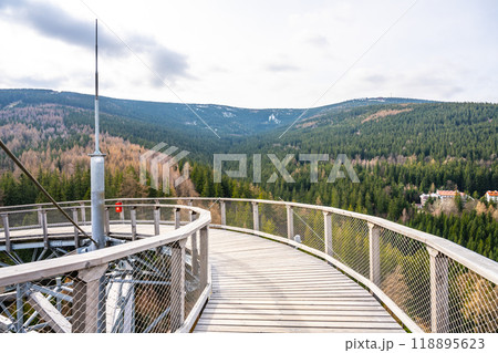 Visitors enjoy breathtaking panoramic views from the Sky Walk Tower in Swieradow Zdroj. The surrounding Jizera Mountains showcase lush forests and distant peaks under a clear sky. Visitors enjoy breathtaking panoramic views from the Sky Walk Tower in Swieradow Zdroj. The surrounding Jizera Mountains showcase lush forests and distant peaks under a clear sky. 118895623