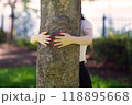 太い幹に手を回す若い女性 118895668