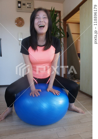 バランスボールに乗る長身女性 118896179