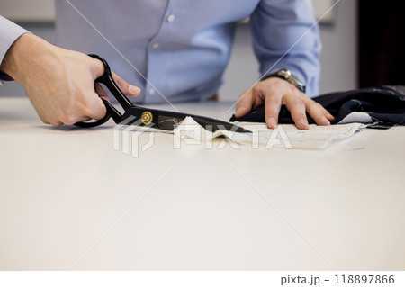 Close-up shot of tailor cutting textile using scissors 118897866