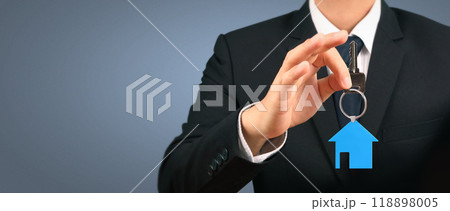 Real estate agent handing over house keys in hand 118898005