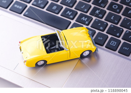 ふたり乗りのオープンカーと、ノートパソコン 118898045