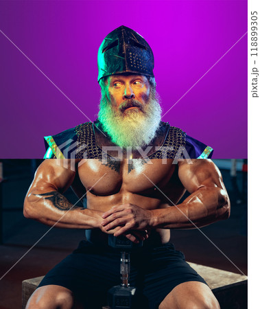 Knight bodybuilder. Creative collage. Elderly bearded man in medieval knight helmet and armor with shirtless male muscular body and dumbbells Knight bodybuilder. Creative collage. Elderly bearded man in medieval knight helmet and armor with shirtless male muscular body and dumbbells 118899305