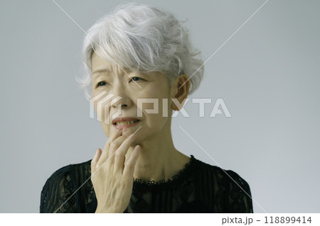 歯茎に手を当てる白髪のシニア女性 118899414