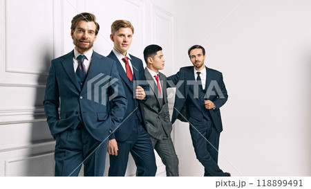 Professional group in suits, exuding confidence and unity. Strong team with focus on success and collaboration posing against white background. 118899491