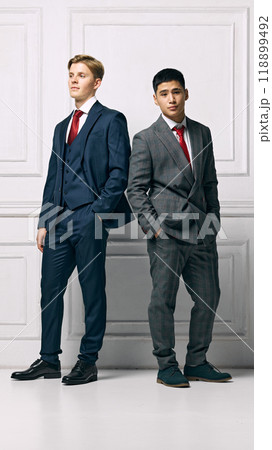 Partnership. Professionals showcasing modern elegance, both present strong and poised stances against white studio background. 118899492