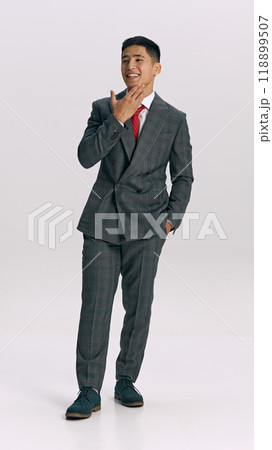 Full-length photo of young man dressed formal sui walking confidently against white studio background. Successful businessman. 118899507