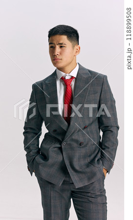 Ready for future challenges, young Asian man, wearing classy formal suit, looking at distance with confident expression against white background. Ready for future challenges, young Asian man, wearing classy formal suit, looking at distance with confident expression against white background. 118899508