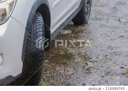 雨の泥道でも安心なオールシーズンタイヤを履いた四輪駆動車 118899743