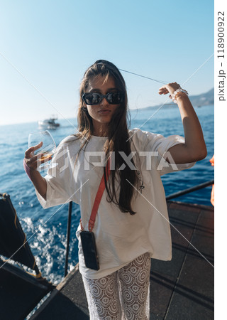 A young woman is having a great time enjoying a beautiful summer day on a boat ride 118900922