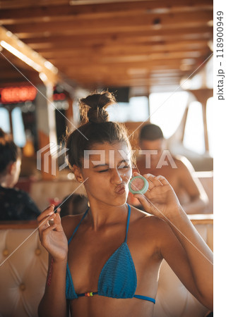 A playful girl embraces summer vibes on a boat with trendy accessories and beachwear 118900949