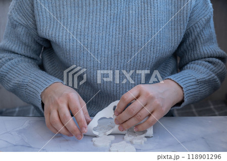 Creator is using white air dry clay for making decor to Christmas tree holiday. Creating hobby recreation activity that involves fingers. DIY crafting 118901296