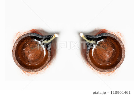 Traditional clay oil lamps with lit wicks on a white background. Top view 118901461