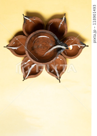 Happy Diwali - Traditional clay diya lamps arrangement on yellow background for festive celebrations. Vertical shot Happy Diwali - Traditional clay diya lamps arrangement on yellow background for festive celebrations. Vertical shot 118901493