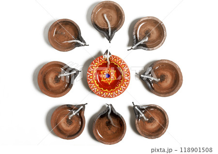 Traditional clay oil lamps are arranged in a circle during Diwali festival. 118901508
