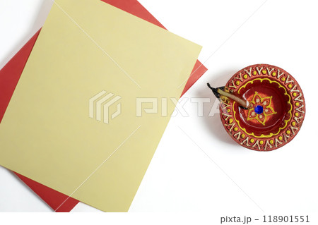 Handmade clay diya lamp with blank greeting card for Diwali festival greetings on white background 118901551