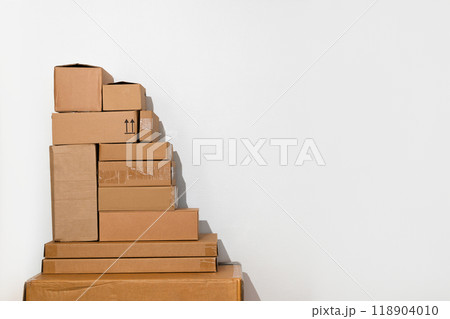 Creative minimalist image of stacked cardboard boxes on a plain background, representing concepts of moving, storage, shipping, and organization. Ideal for themes of simplicity and efficiency. 118904010
