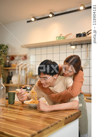 Young cheerful couple eating pasta, having lunch together at home. Love, relationships and food concept Young cheerful couple eating pasta, having lunch together at home. Love, relationships and food concept 118904181