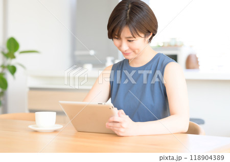 タッチペンを手にタブレット端末を操作する女性 118904389