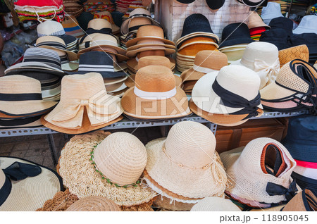 assortment of men's and women's beach hats on counter at the street market assortment of men's and women's beach hats on counter at the street market 118905045