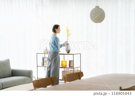 部屋にお花を飾る30代女性 118905843