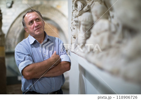 Male collector evaluates the exhibition in the historical museum Male collector evaluates the exhibition in the historical museum 118906726