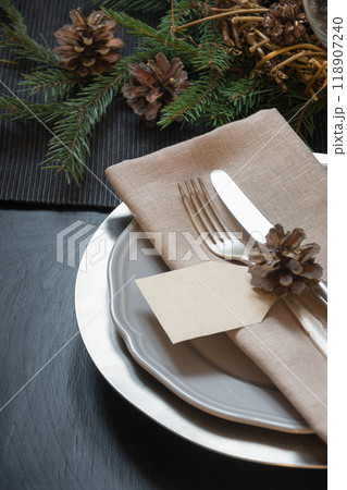 Christmas table setting with silverware and dark natural evergreen decor on black table. Top view. Holiday Centerpieces. 118907240