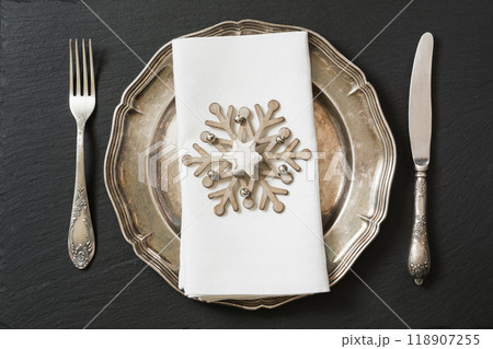 Christmas table setting with vintage dishware, silverware and snowflake decorations. Christmas table setting with vintage dishware, silverware and snowflake decorations. 118907255