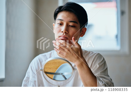 肌を気にする20代の若い男性 肌を気にする20代の若い男性 118908335
