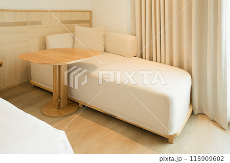 Modern beige sofa paired with attached round table. 118909602