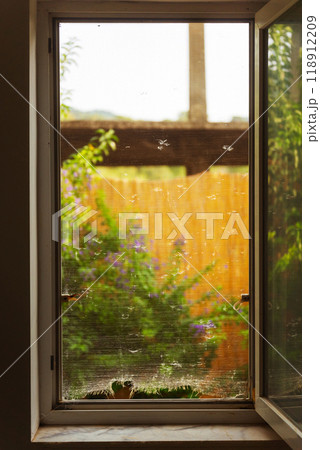 Old mosquito net with holes on the window 118912209