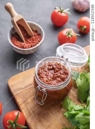 Homemade tomato sauce for pizza or pasta in a jar on a gray background with fresh vegetables Homemade tomato sauce for pizza or pasta in a jar on a gray background with fresh vegetables 118912386