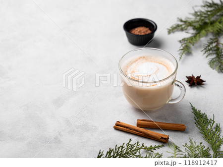 Spiced coffee latte or cappuccino with cinnamon sticks and anise star on a light background Spiced coffee latte or cappuccino with cinnamon sticks and anise star on a light background 118912417