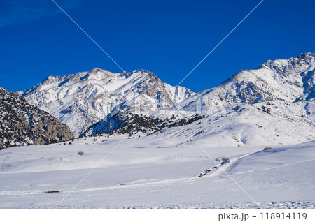 Winter landscape with mountains covered snow under blue sky in cold sunny day 118914119