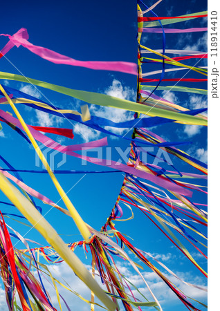 Multicolored ribbons or garlands flutter in the wind on a summer sunny day with a blue sky  Multicolored ribbons or garlands flutter in the wind on a summer sunny day with a blue sky  118914410