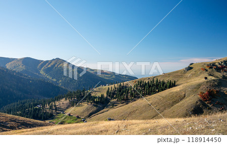Beautiful autumn mountain landscape with colorful trees, blue sky and old houses in sunny day. Beautiful autumn mountain landscape with colorful trees, blue sky and old houses in sunny day. 118914450