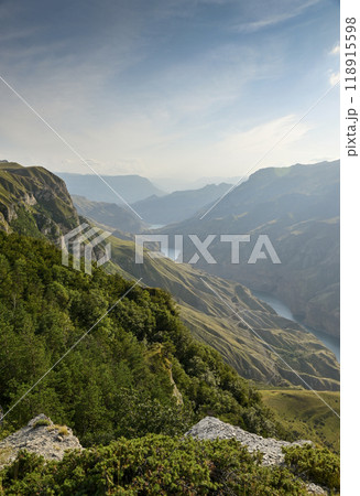 A beautiful landscape of mountains with bushes, rocks and a blue river on a summer day. Sulak Canyon 118915598