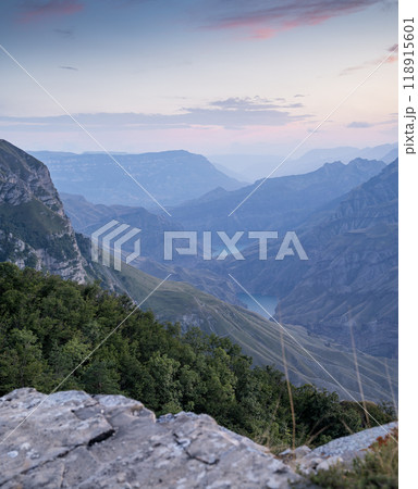 A beautiful landscape of mountains with bushes, rocks and a river on a summer day at sunset. A beautiful landscape of mountains with bushes, rocks and a river on a summer day at sunset. 118915601