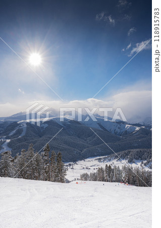 Beautiful landscape of the Arkhyz ski resort with mountains, snow, forest and track  118915783